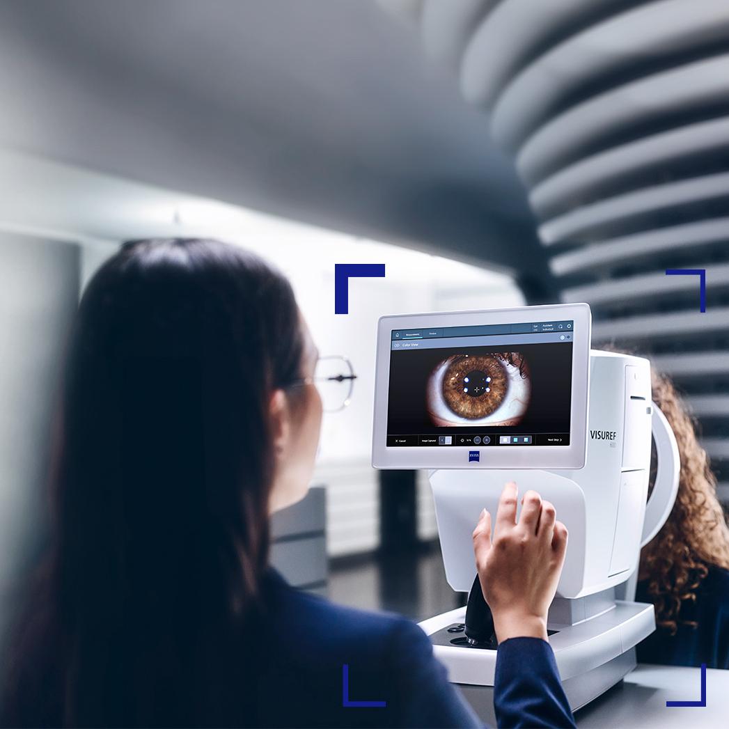 Žena optička se dívá na obrazovku přístroje ZEISS VISUREF 600, který zobrazuje obraz oka.