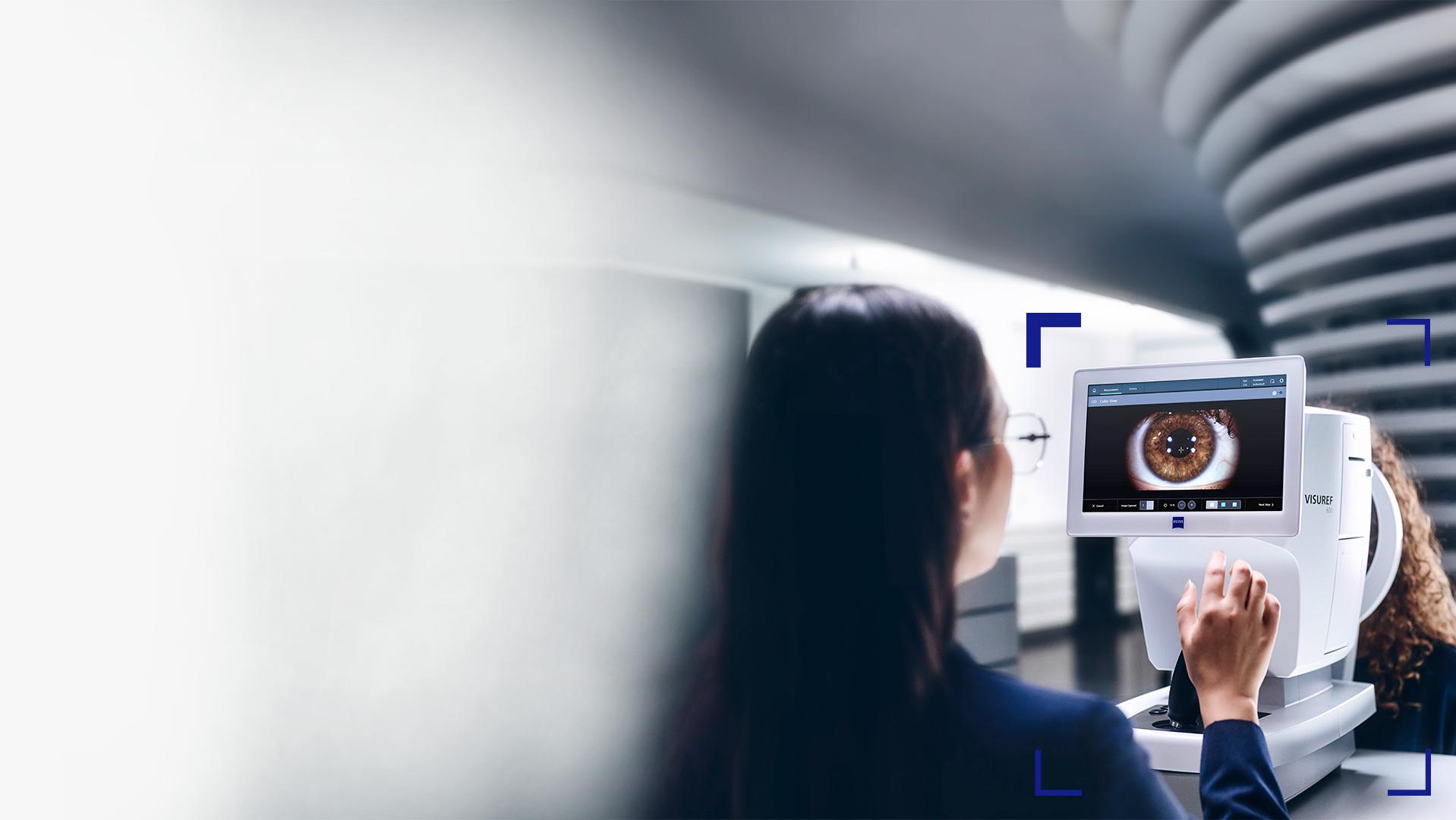 Žena optička se dívá na obrazovku přístroje ZEISS VISUREF 600, který zobrazuje obraz oka.