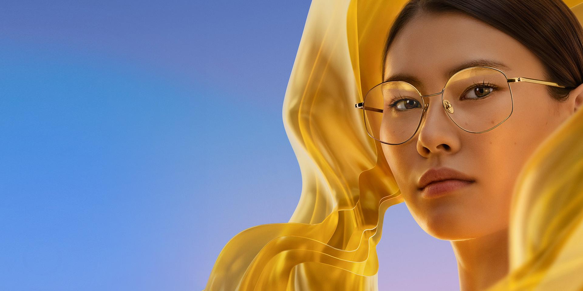 Žena v čirých brýlích s povrchovou úpravou ZEISS DuraVision Gold UV, která brýlovým čočkám dodává decentní, ale osobitý odlesk.