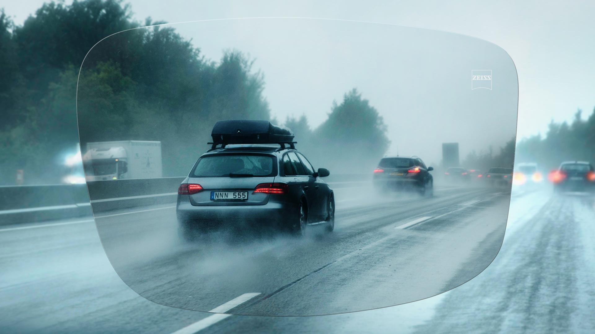 Pohled přes jednoohniskové brýlové čočky ZEISS DriveSafe na deštivou dálnici. 