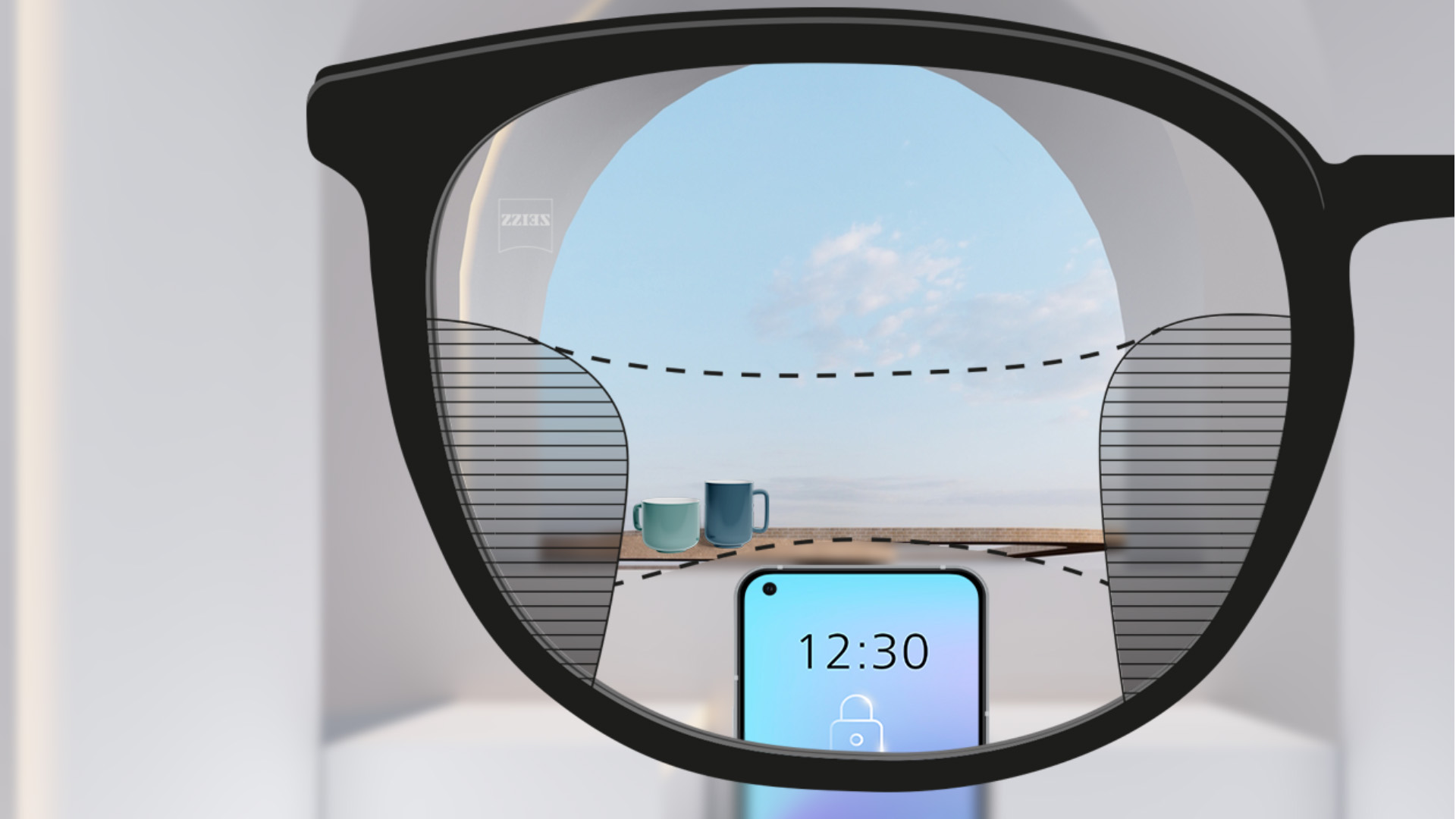 Obrázek zorného pole s progresivními čočkami ZEISS SmartLife, přes které je ostře vidět chytrý telefon s pohárky v pozadí, nalevo a napravo jsou vidět úzké dílce.