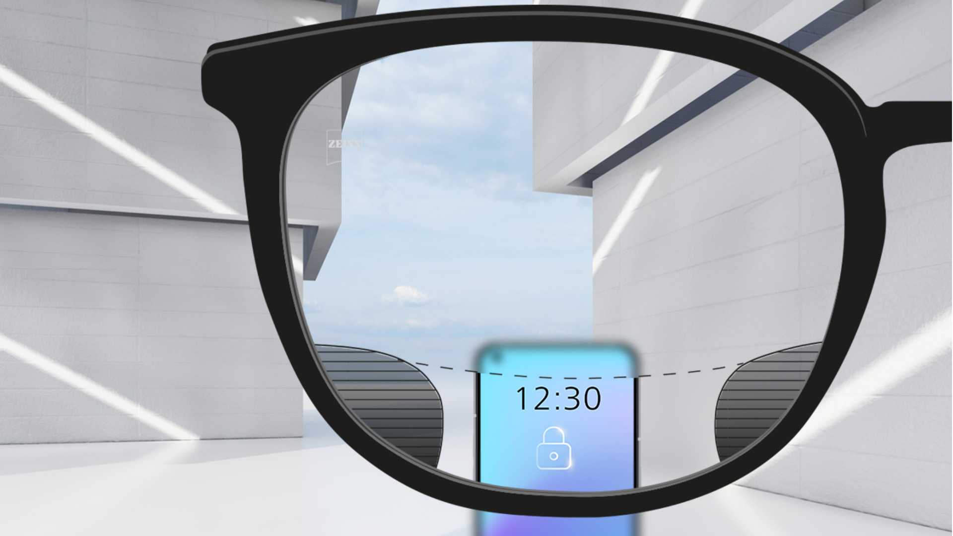 Obrázek zorného pole s brýlovými čočkami ZEISS Digital SmartLife, přes které je ostře vidět chytrý telefon v horní a spodní části brýlových čoček a nalevo a napravo jsou vidět rozmazané dílce.