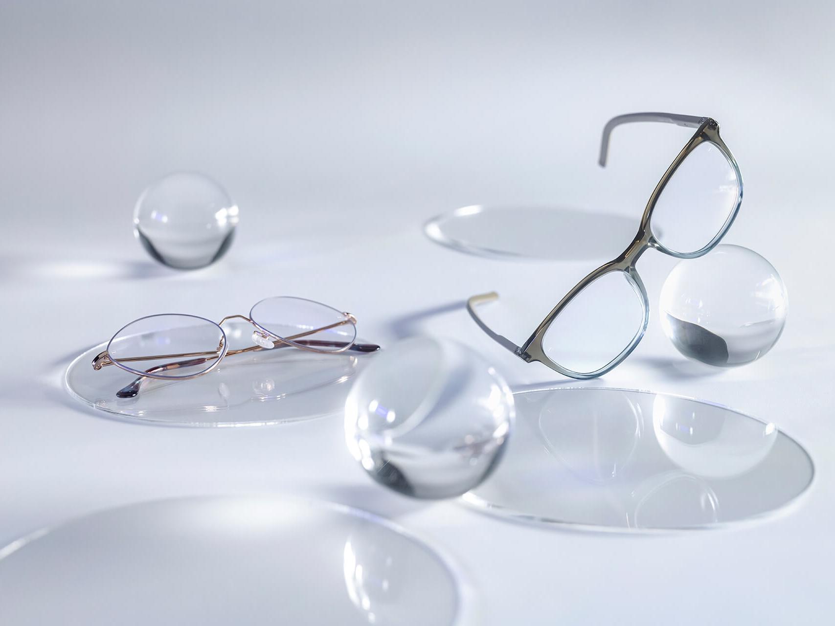 Brýle osazené čočkami ZEISS s vrstvou DuraVision® Silver, od kterých se v porovnání s okolními skleněnými koulemi neodráží žádné světlo.