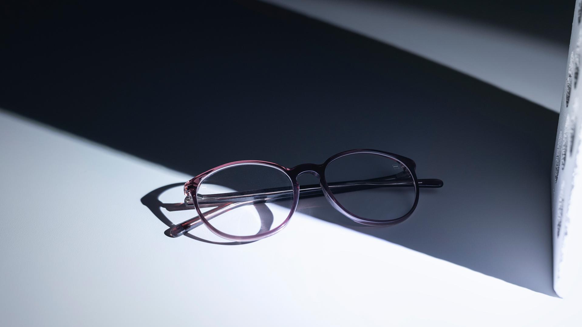 Brýle s čočkami ZEISS a vrstvami DuraVision®, které jsou z poloviny ve stínu a z poloviny na slunci.