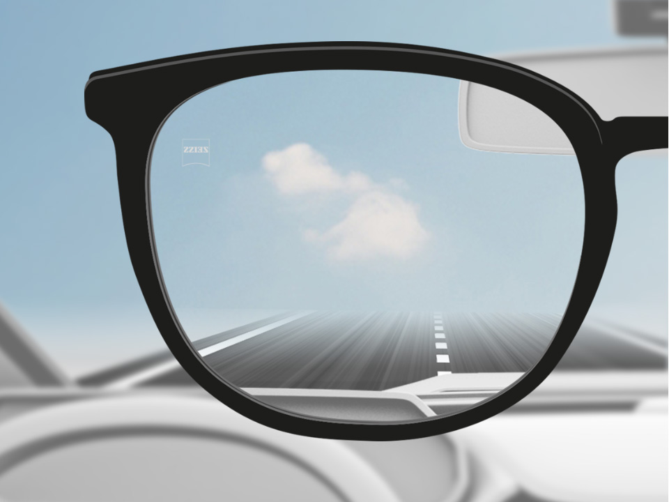 Obrázek řidiče auta s jednoohniskovými čočkami ZEISS DriveSafe, přes které je ostře vidět. 