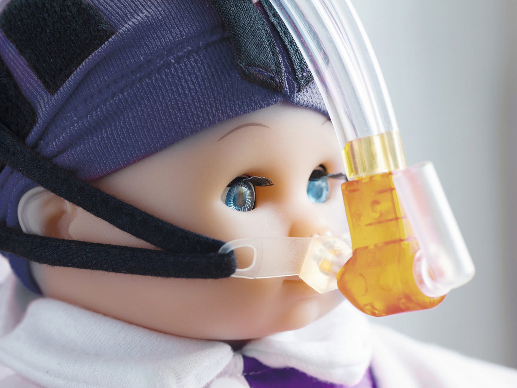 Blízký záběr na obličej panenky s nasazenou dýchací maskou.